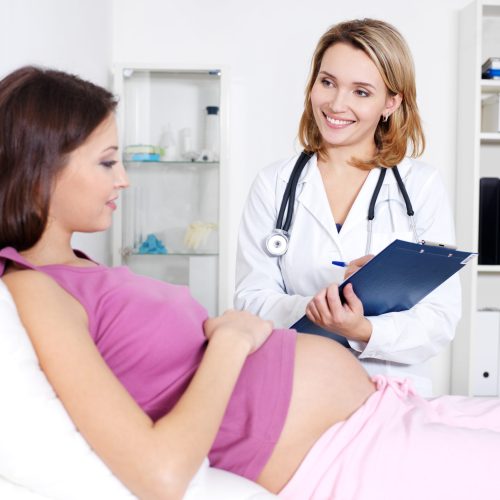 Consultation of pregnant young woman with doctor in hospital - indoors